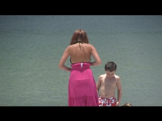 mom takes off her dress on the beach